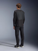 Alpinestars Tech-Air 3 V2 System, Black autonomous motorcycle airbag vest, rear view worn by a model with black riding pants, features a lightweight and slim profile, red logo on lower back, advanced rider safety gear for touring and commuting