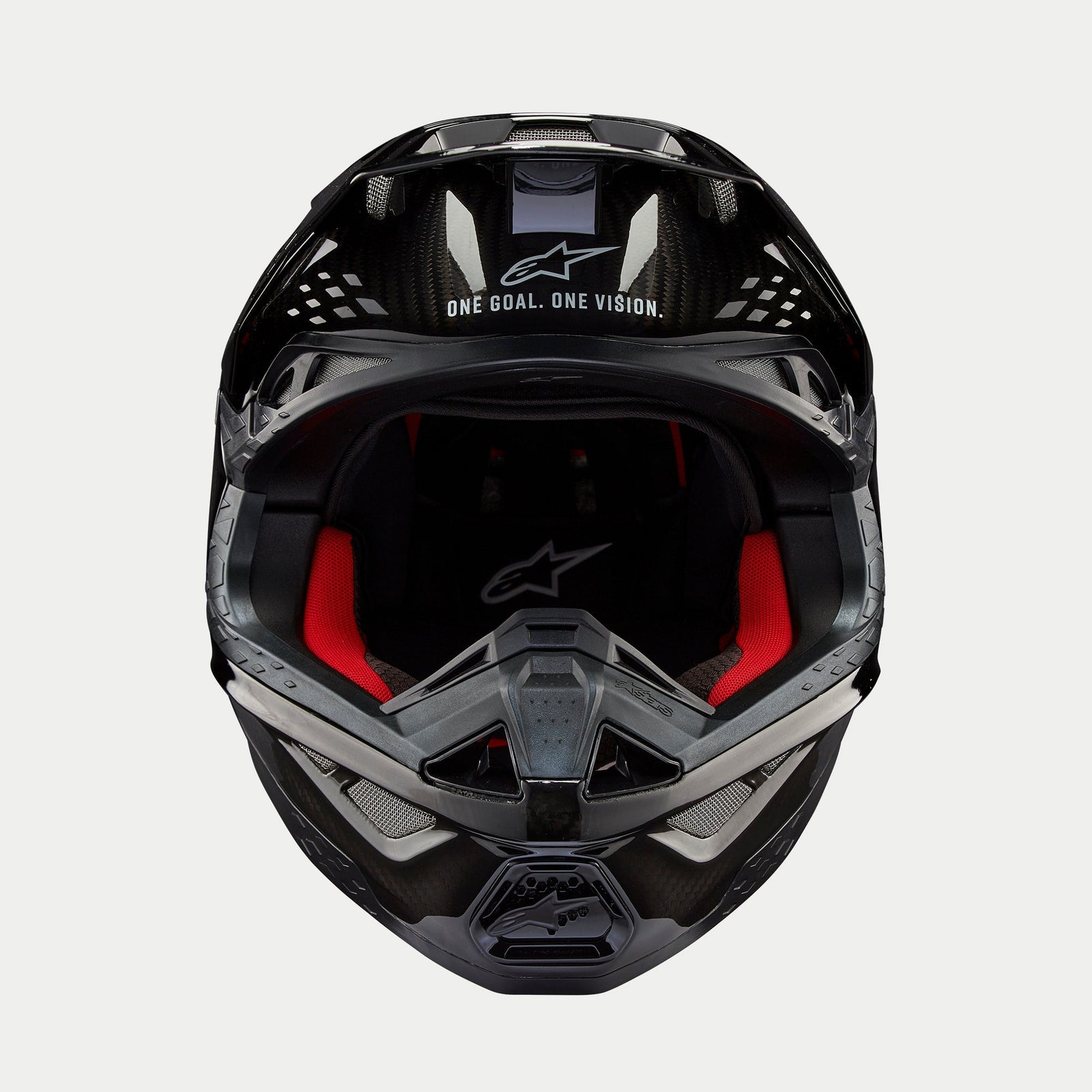 Alpinestars Supertech M10 Solid Helm, Motocross-Helm, Glänzend Schwarzes Carbon, Vorderansicht mit rotem Innenfutter, Carbonfaser-Schale und „ONE GOAL. ONE VISION.“ Slogan im Visierbereich