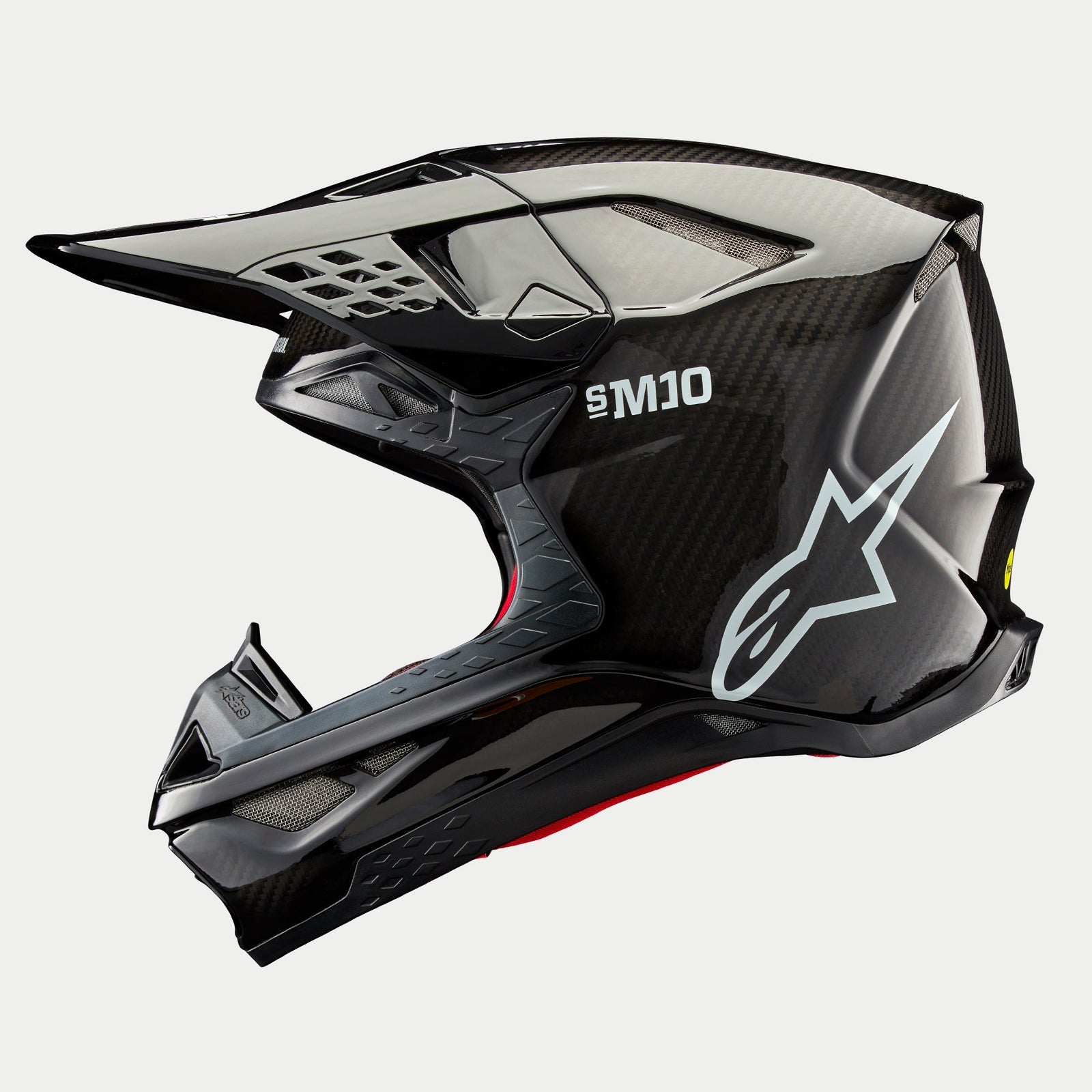 Alpinestars Supertech M10 Solid Helm, Motocross-Helm, Schwarz glänzendes Carbon, Seitenprofil mit sichtbarem Carbonfasergewebe, weißes SM10-Branding und Alpinestars-Logo, stromlinienförmiges aerodynamisches Design mit netzabgedeckten Belüftungsöffnungen