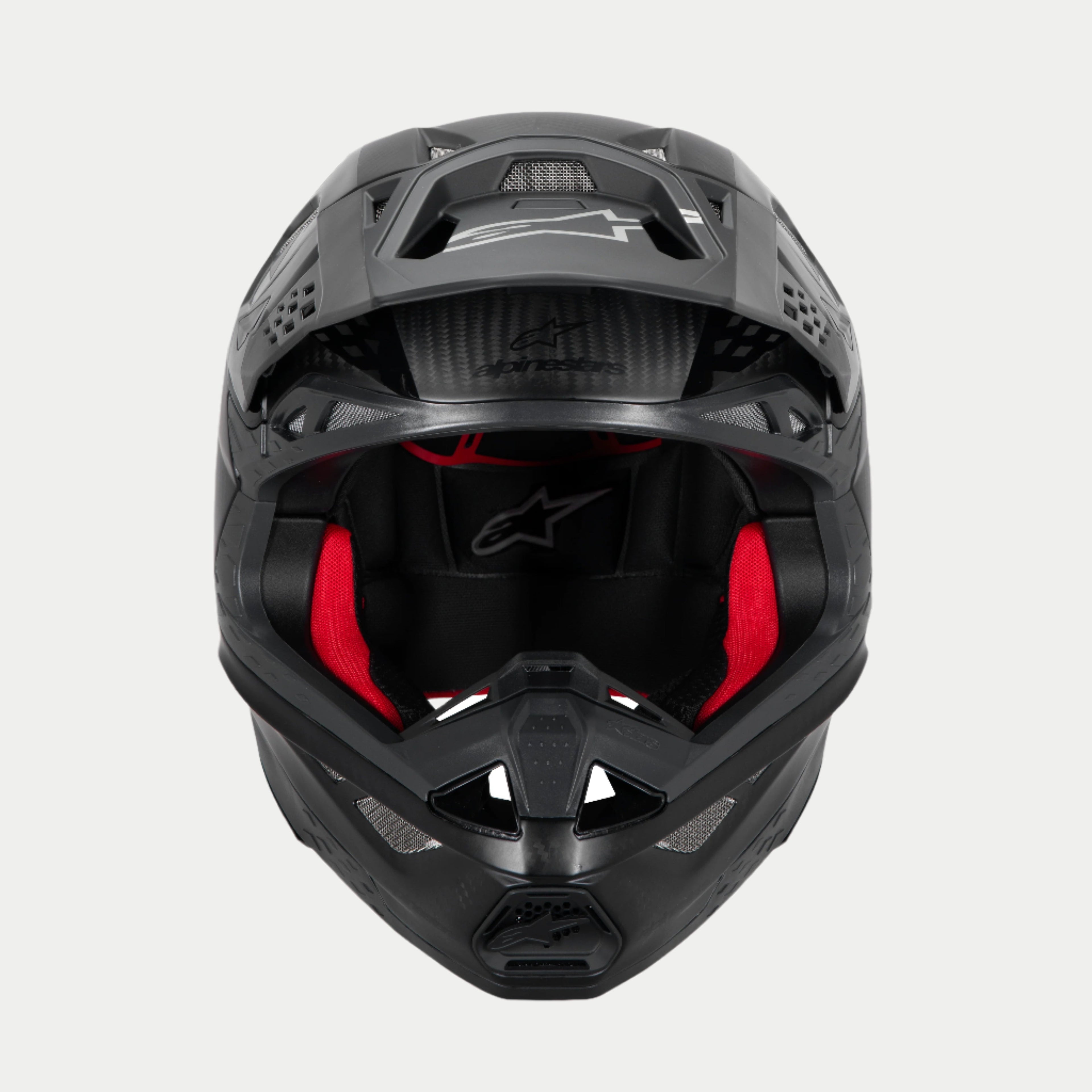 Alpinestars Supertech M10 Fame ECE 22.06 Helm, Motocross-Helm, Schwarz Carbon Matt und Glänzend, Frontansicht mit sichtbarer roter Innenpolsterung, aerodynamische Carbonfaserschale, belüftetes Design für den Offroad-Rennsport