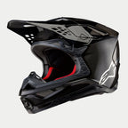 Alpinestars Supertech M10 Fame ECE 22.06 Helm, Motocross-Helm, Schwarz-Carbon in mattem und glänzendem Finish, mit sichtbarem Carbonfaser-Gewebe, weißem Astar-Logo an der Seite und roter Innenpolsterung, aerodynamisches Offroad-Design