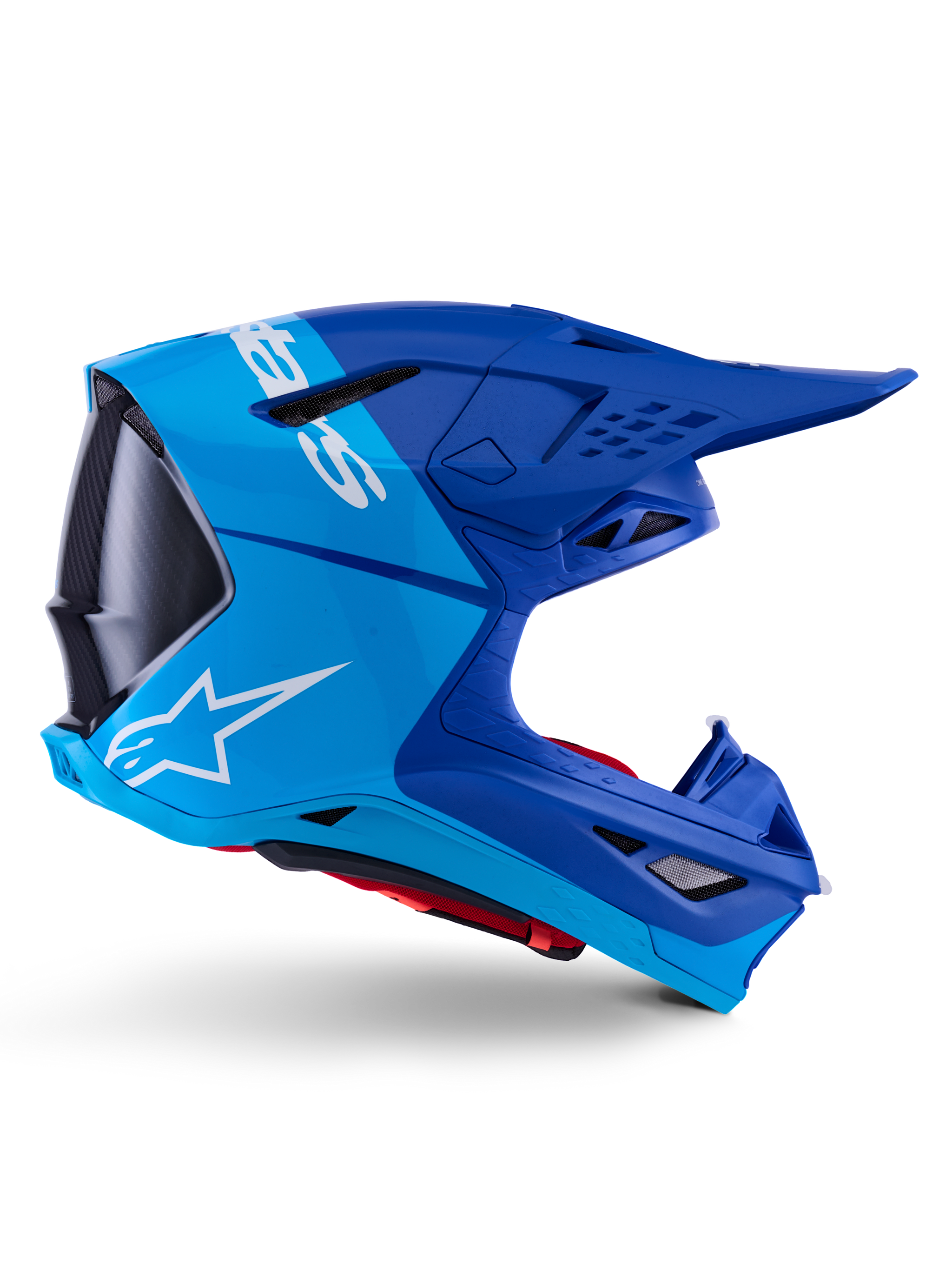 Alpinestars Supertech M10 Flood Helm, Motocross-Helm, Metallic-Blau und Mittelblau mit schwarzen Carbon-Akzenten, Seitenansicht, mit weißem Logo, aerodynamisches Design mit Belüftungsöffnungen, Details mit Carbonfaser-Textur, professioneller Schutz für den Offroad-Rennsport