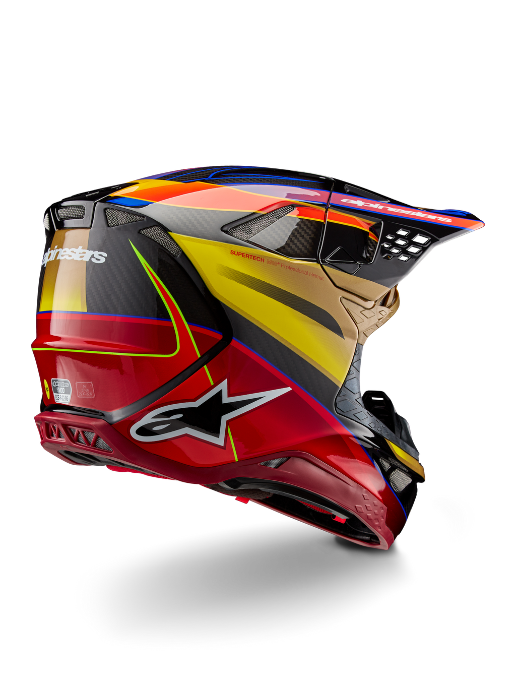 Alpinestars Supertech M10 Era Helm, Motocross-Helm, Goldgelb Rio-Rot Glänzend, Dreiviertelansicht von hinten mit Kohlefaserschale, roten und gelben Grafiken, blauen Akzenten, aerodynamisches Profil mit mehreren Belüftungsöffnungen und markantem Astar-Logo.