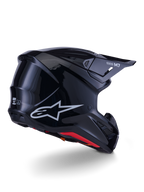 Alpinestars S-M7 Solid Helmet, Motocross Helmet, Glossy Black, featuring a sleek aerodynamic shell with a silver Astars logo, red interior trim, and integrated ventilation ports, designed for off-road racing protection