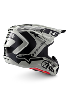 Alpinestars Limited Edition S-M7 Wolf Dust Helm, Motocross-Helm, Dune Black Glossy, hellgraue Schale mit markanten schwarzen Alpinestars-Grafiken und Schriftzügen im Gothic-Stil, aerodynamisches Design mit mehreren Belüftungsöffnungen, rote Innenpolsterung, hochwertiger Offroad-Kopfschutz