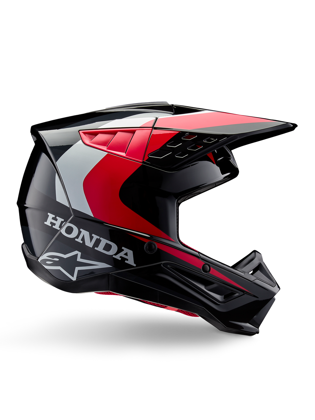 Honda S-M5 Helm, Motocross-Helm, Schwarz-Rot glänzend mit weißen und silbernen Akzenten, Seitenansicht mit Honda- und Alpinestars-Logos, aerodynamisches Design mit Visier und mehreren Belüftungsöffnungen, professionelle Offroad-Schutzausrüstung