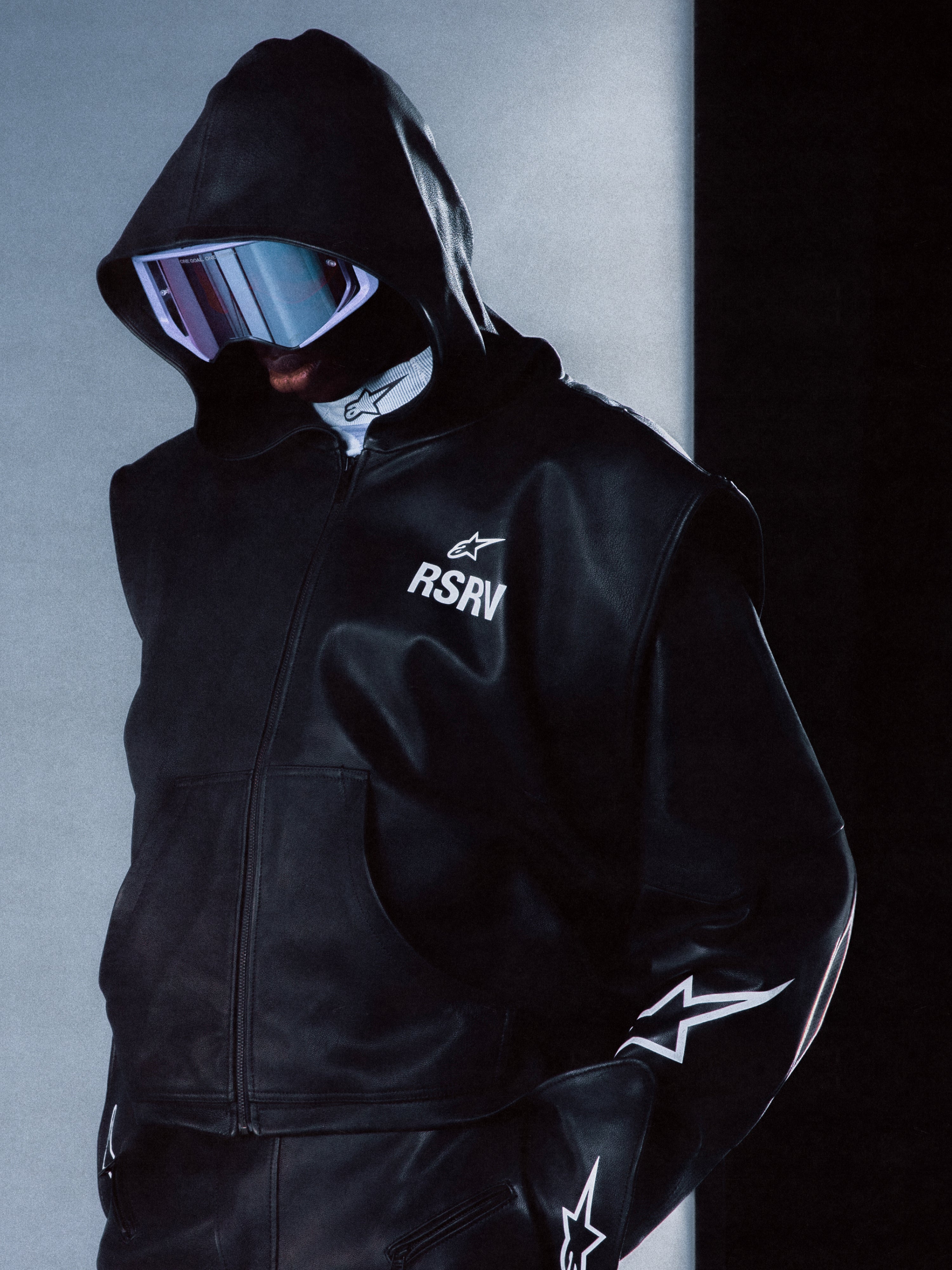 RSRV Axis Leather Hoodie, Black Leather Jacket with Hood, Unisex Streetwear, Reflective Goggles, White Star Logo Details, Premium Leather Construction, Sleek Futuristic Design