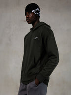 Alpinestars Essentials Ageless Hoodie, Off Black, männliches Model in lässiger Streetwear, dunkelgraues Fleece mit Stone-Wash-Finish und kleinem weißen Stern-Logo, kombiniert mit einer schwarzen Alpinestars Beanie und einer grauen Hose