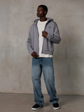 Alpinestars Essentials Ageless Zip Hoodie, Silber, lässige Streetwear, Fleece-Kapuzenjacke mit Reißverschluss, kleines schwarzes Logo auf der Brust, getragen von einem Model mit weißem T-Shirt und blauer Jeans, entspannte Lifestyle-Passform
