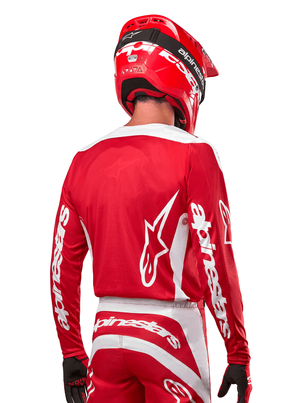 Motocross-Fahrer im Alpinestars 2024 Fluid Lurv Trikot, Mars Rot und Weiß, Rückansicht mit weißem Alpinestars-Logo auf dem Rücken und Branding an den Ärmeln, kombiniert mit einem passenden roten Helm und schwarzen Handschuhen, professionelle Offroad-Rennausrüstung