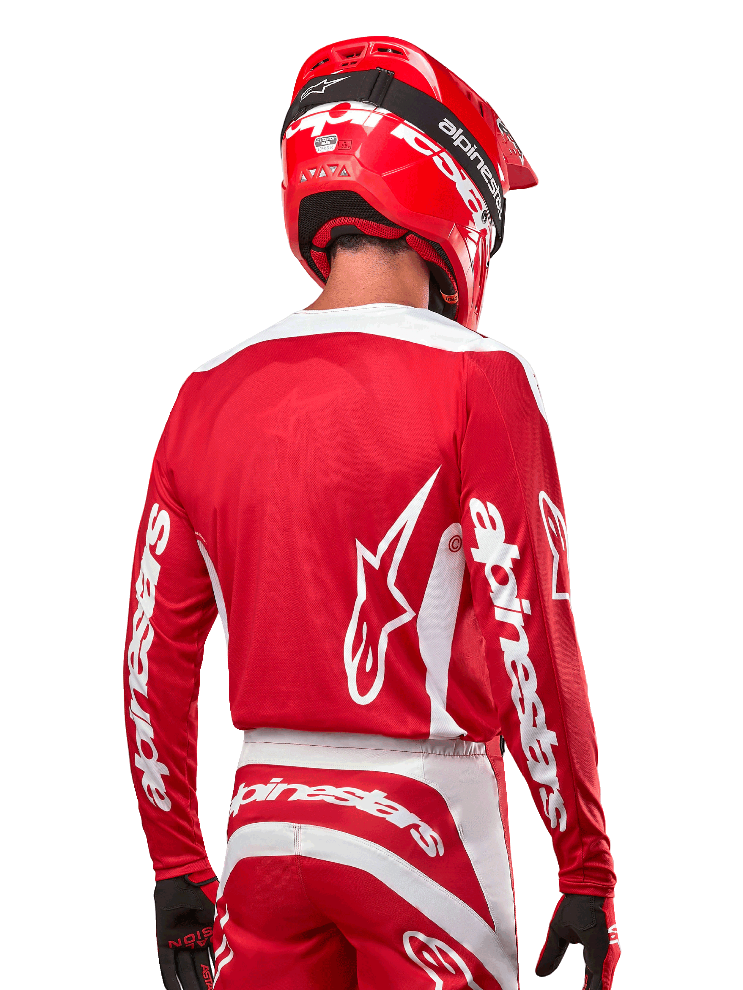 Motocross-Fahrer im Alpinestars 2024 Fluid Lurv Trikot, Mars Rot und Weiß, Rückansicht mit weißem Alpinestars-Logo auf dem Rücken und Branding an den Ärmeln, kombiniert mit einem passenden roten Helm und schwarzen Handschuhen, professionelle Offroad-Rennausrüstung