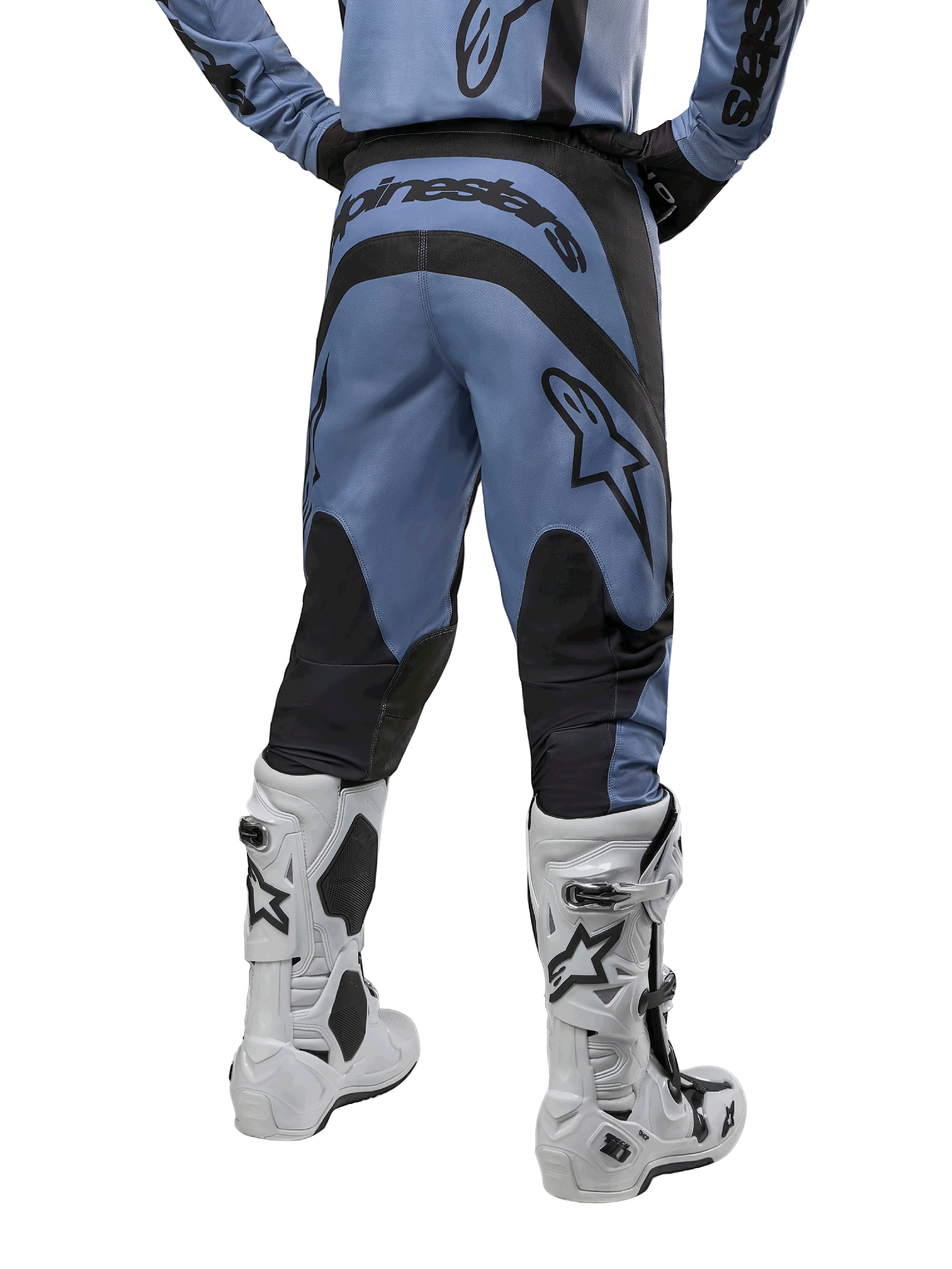 Alpinestars 2024 Fluid Lurv Hose, Motocross-Hose, Hellblau und Schwarz, Rückansicht mit schwarzen verstärkten Einsätzen und großem Markenlogo, kombiniert mit weiß-schwarzen Motocross-Stiefeln, professionelle Rennausrüstung für den Offroad-Einsatz