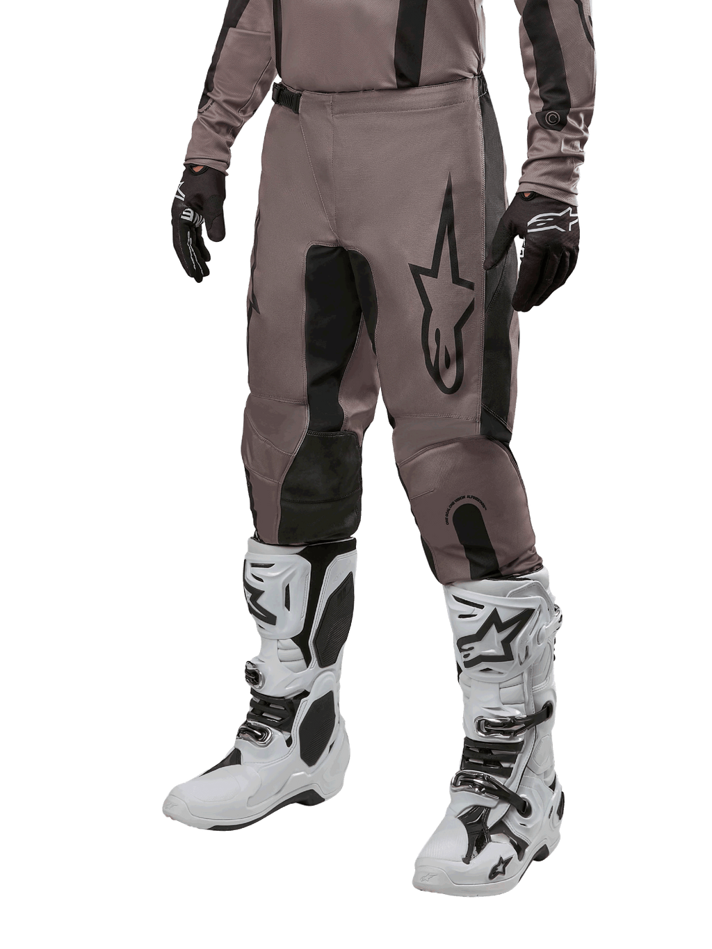 Alpinestars 2024 Fluid Lurv Hose, Motocross-Hose, Mud Black und Schwarz, mit Alpinestars-Logo, getragen mit schwarzen Handschuhen und weißen Motocross-Stiefeln, sportliches Design für Offroad-Rennsport