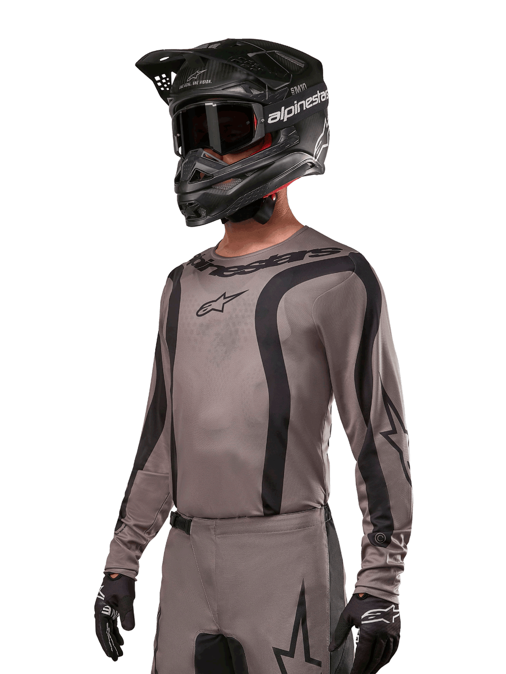 Alpinestars 2024 Fluid Lurv Trikot, Motocross-Jersey, Mud Black und Grau, langärmliges Design mit geschwungenen schwarzen Streifen und Logos, getragen mit passender Hose und einem schwarzen Motocross-Helm, abgestimmte Offroad-Rennausrüstung