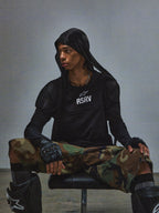 Alpinestars RSRV Nucleon SS Tee, Schwarzes T-Shirt mit RSRV-Aufdruck, Urban Streetwear, Getragen mit Kapuzenpullover, Tarnhose und Knieschützern, Moderner Tactical-Style