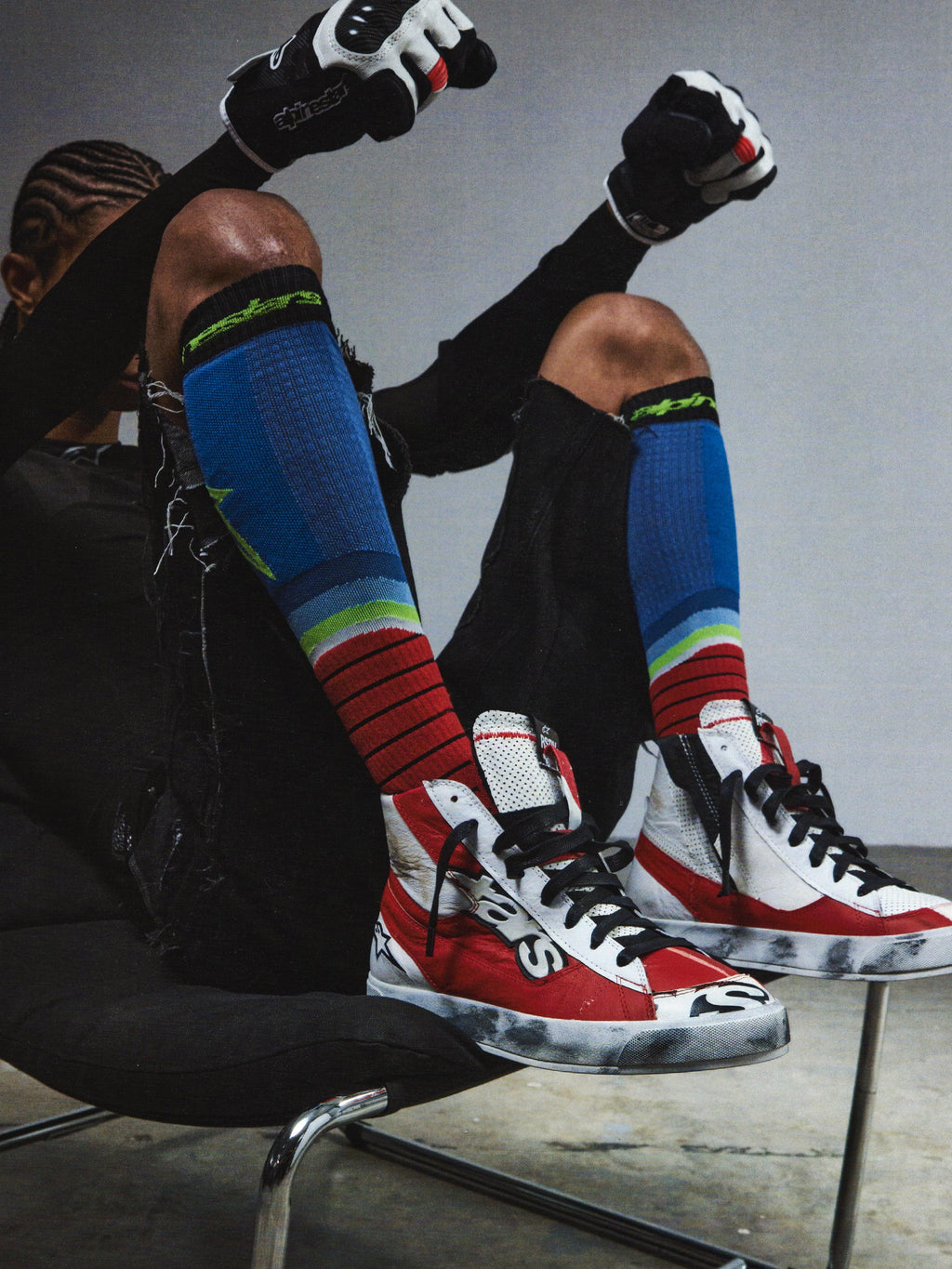 Alpinestars RSRV Legacy Shoe, Lifestyle-Sneaker, Rot und Weiß mit Schwarzen Akzenten, Premium-Konstruktion, Person trägt bunte Kniestrümpfe und schwarze Handschuhe