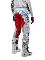 Alpinestars 2024 Racer Hana Hose, Motocross-Hose, Weiß Mehrfarbig mit roten und blauen Akzenten, Rückansicht mit großem Branding am Gesäß, getragen mit weiß-schwarzen Motocross-Stiefeln, entwickelt für Offroad-Performance und Langlebigkeit