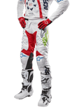2024 Racer Hana Hose, Motocross-Hose, Weiß mit roten, blauen und limettengrünen Akzenten, schützendes Design mit Kniepaneelen aus Leder, getragen mit passendem Jersey, roten Handschuhen und weißen Stiefeln mit Schnallen, sportliches Motorsport-Outfit