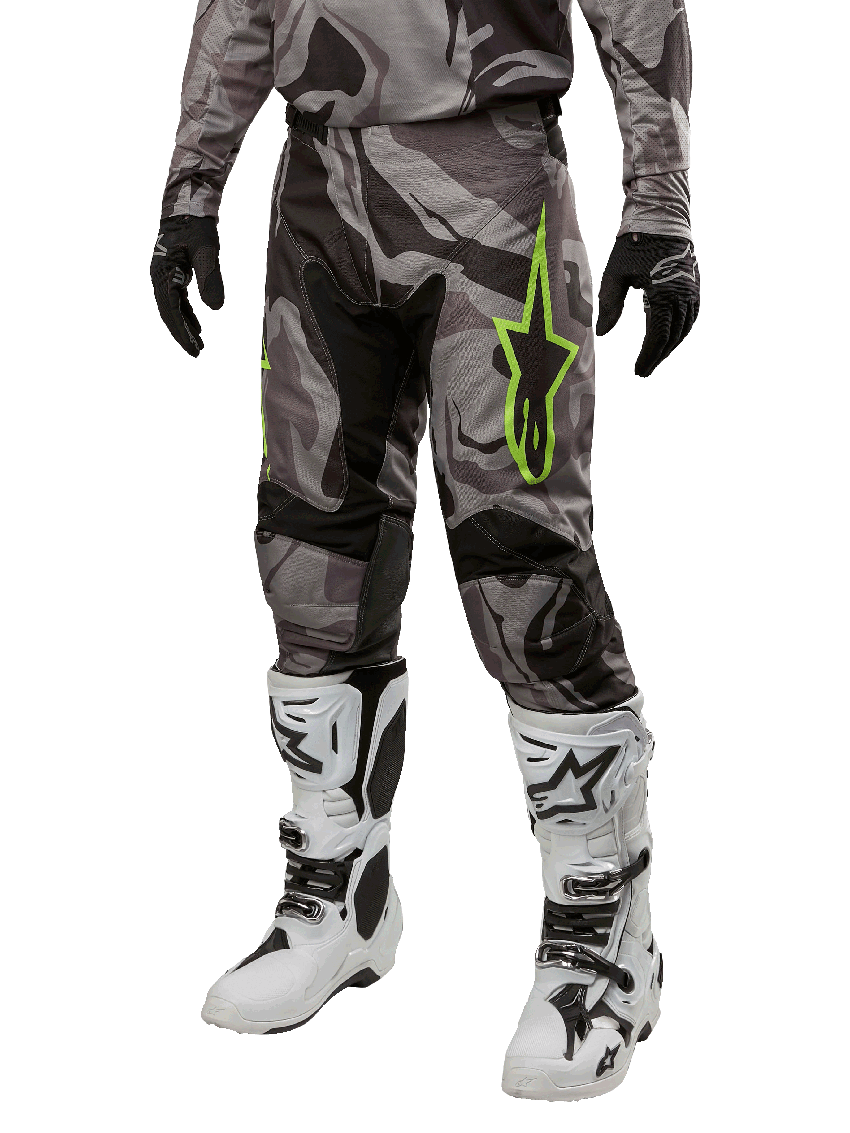 Alpinestars 2024 Racer Tactical Hose, Motocross-Hose, Grau und Schwarz Tarnmuster, neongrünes Stern-Logo, getragen mit weiß-schwarzen Stiefeln und schwarzen Handschuhen, Geländefahrt-Ausrüstung