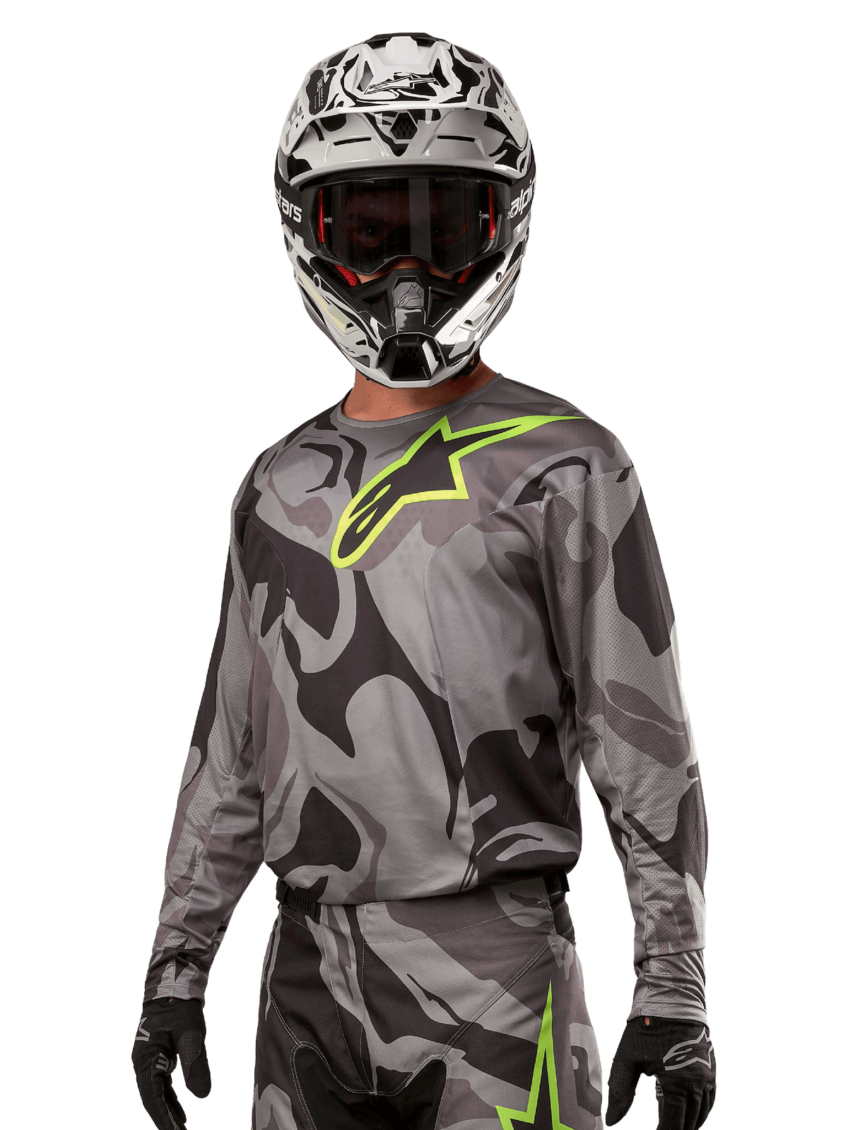Alpinestars 2024 Racer Tactical Jersey, Motocross-Trikot, Cast Gray Camo Magnet mit neongrünem Logo, getragen mit schwarz-weißem Helm und schwarzen Handschuhen, technisches feuchtigkeitsableitendes Material für Offroad-Rennsport
