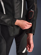Nahaufnahme des Alpinestars Stella GP-R7 2-Teiler-Lederanzugs in Schwarz, mit Fokus auf die Reißverschluss-Anpassung am Unterarm, mit perforierter Lederkonstruktion, weißen Akzenten und dem Tech-Air-kompatiblen Branding am Ärmel.