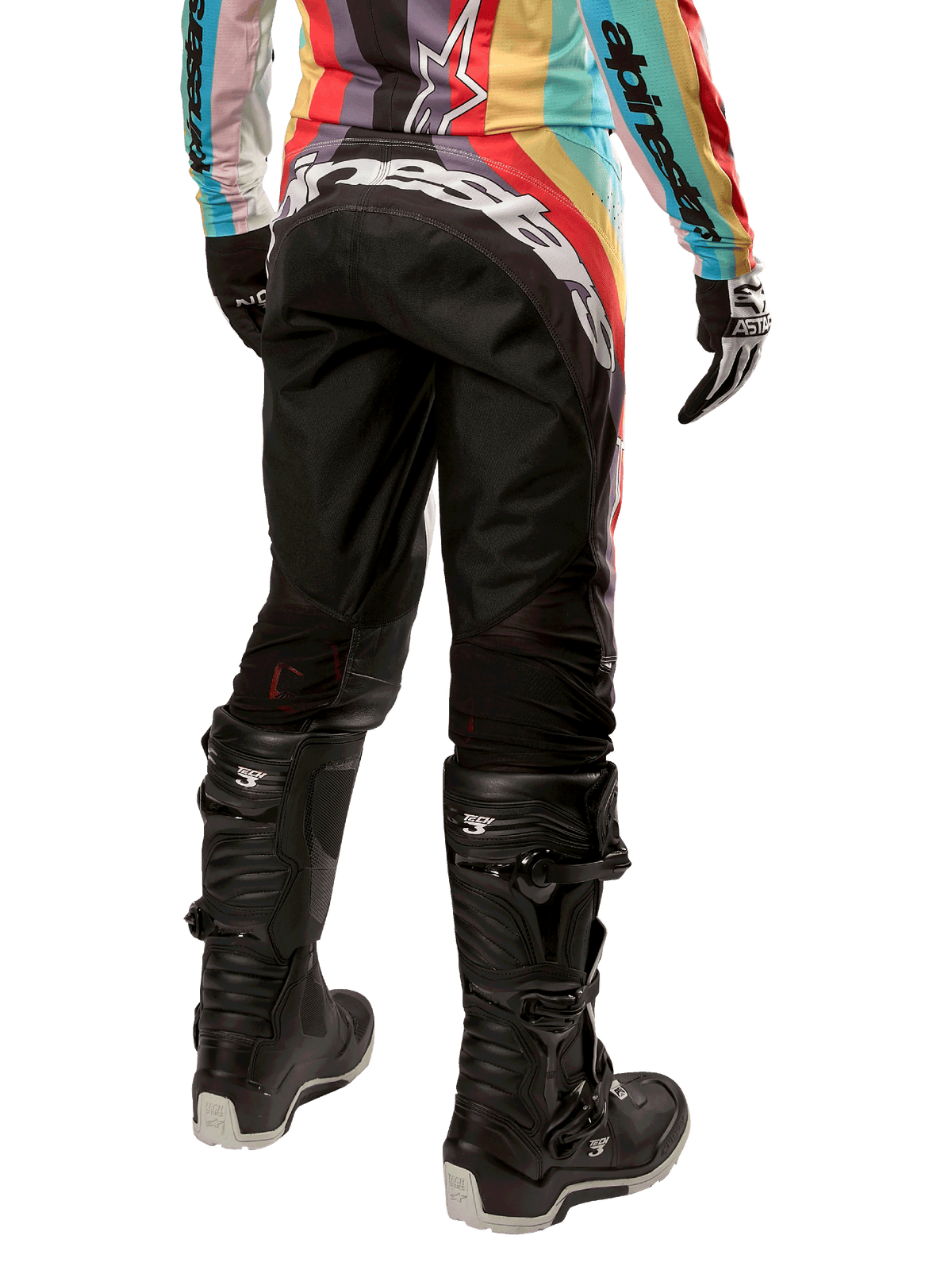 Alpinestars Damen Stella 2024 Techstar Hose, Motocross-Hose, Schwarz-Mehrfarbig, Rückansicht mit markantem weißem Branding auf dem Gesäß, getragen mit schwarzen Tech 3 Stiefeln und passendem mehrfarbigem Trikot, professionelle Offroad-Rennbekleidung.