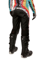 Alpinestars Damen Stella 2024 Techstar Hose, Motocross-Hose, Schwarz-Mehrfarbig, Rückansicht mit markantem weißem Branding auf dem Gesäß, getragen mit schwarzen Tech 3 Stiefeln und passendem mehrfarbigem Trikot, professionelle Offroad-Rennbekleidung.