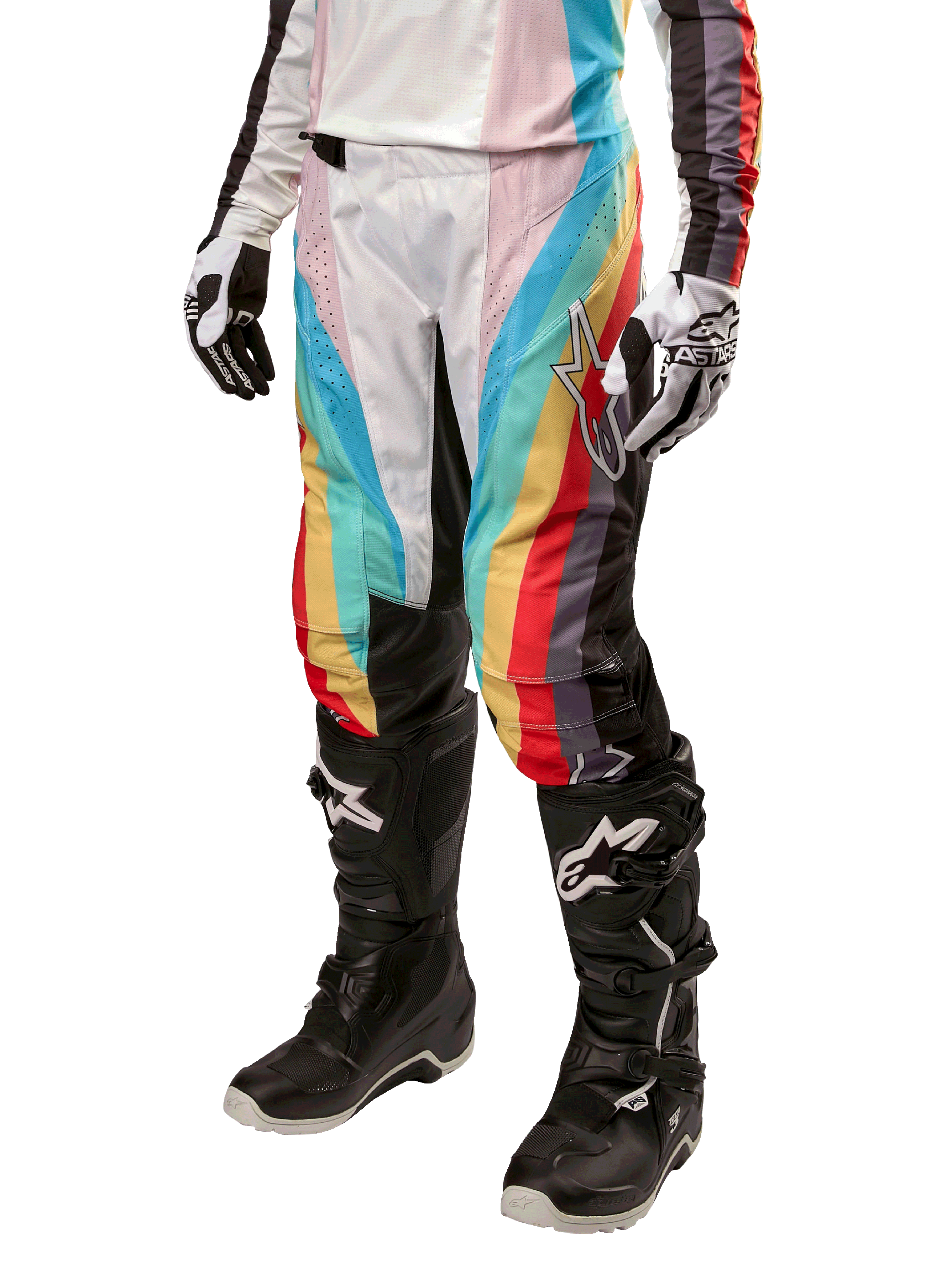 Alpinestars Stella 2024 Techstar Damenhose, Motocross-Hose, Schwarz-Mehrfarbig mit diagonalen roten, gelben und blauen Streifen, getragen mit schwarzen Stiefeln und weißen Handschuhen, mit schützenden schwarzen Knieeinsätzen und markantem Branding für Offroad-Rennen.