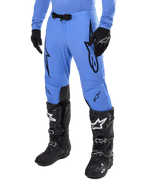 Alpinestars 2024 Supertech Dade Hose, Motocross-Hose, Hellblau mit schwarzen Grafiklogos, mit Belüftungsperforationen und einer magnetischen Taillenschnalle, kombiniert mit schwarzen technischen Motorradstiefeln und Handschuhen, professionelle Offroad-Rennausrüstung