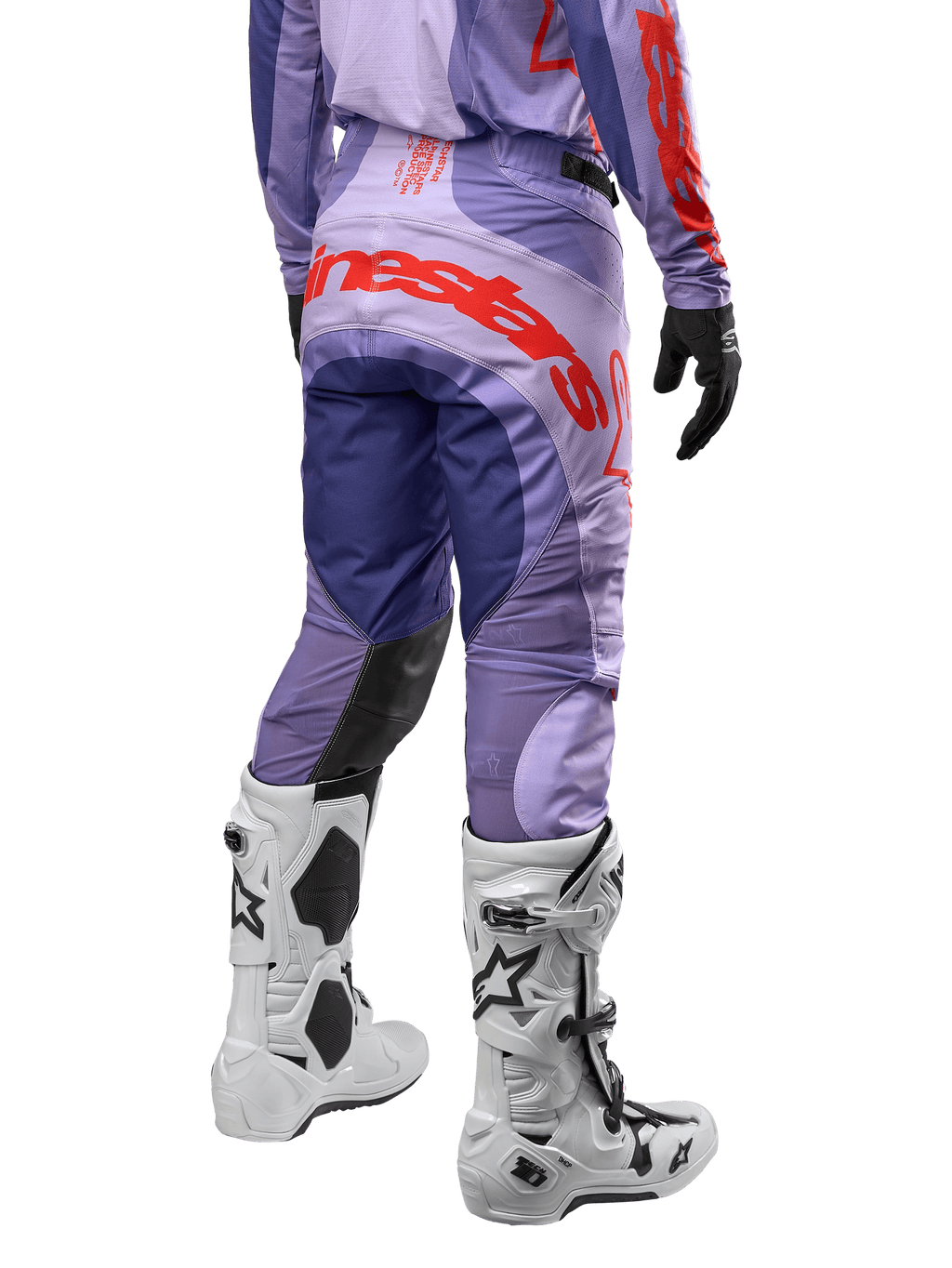 Alpinestars 2024 Techstar Ocuri Hose, Motocross-Hose, Lila und Hot Orange, Rückansicht mit markantem Alpinestars-Schriftzug auf dem Gesäß, weiße Stiefel, schwarze Handschuhe, professionelle Offroad-Ausrüstung