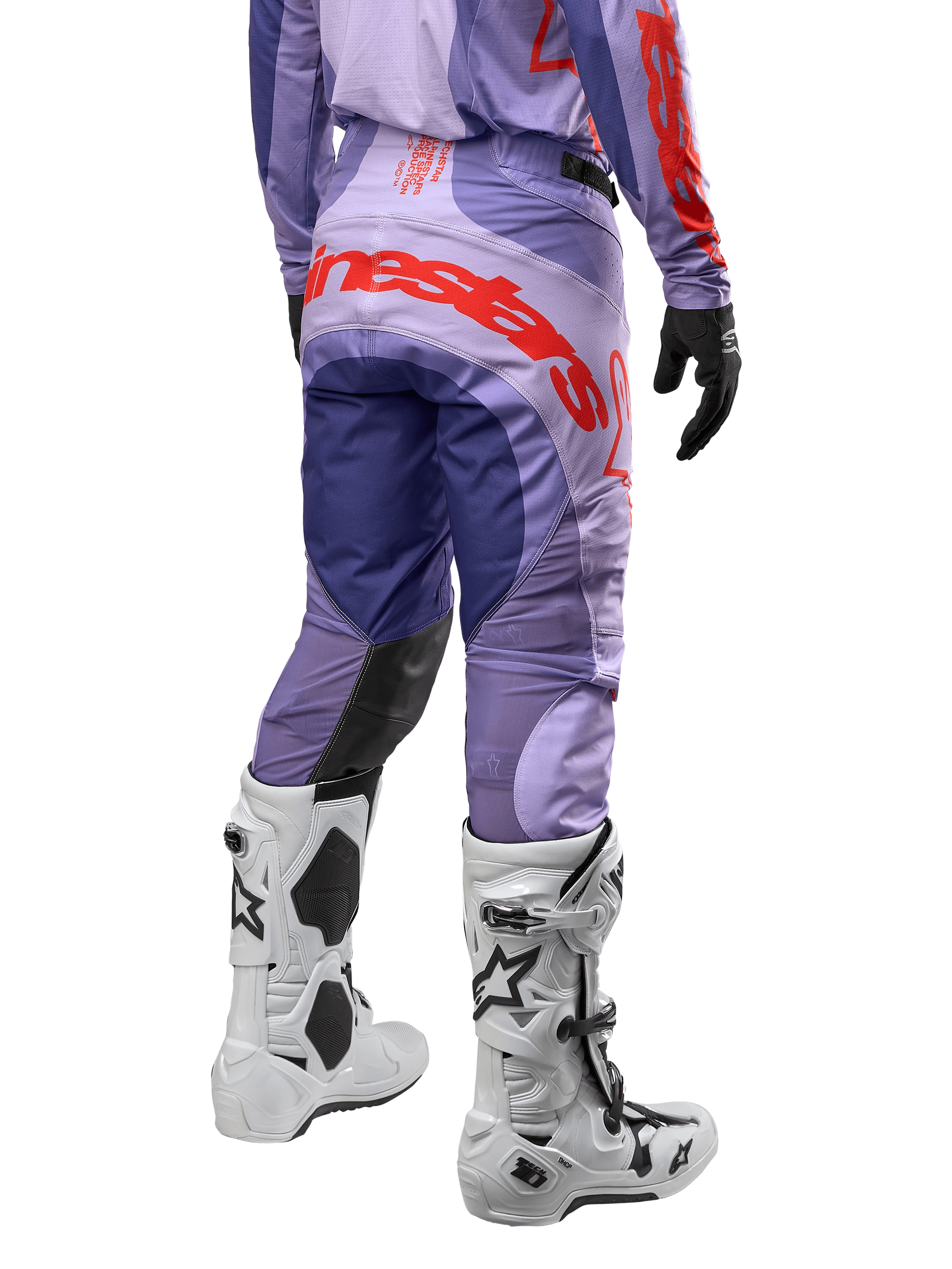 Alpinestars 2024 Techstar Ocuri Hose, Motocross-Hose, Lila und Hot Orange, Rückansicht mit markantem Alpinestars-Schriftzug auf dem Gesäß, weiße Stiefel, schwarze Handschuhe, professionelle Offroad-Ausrüstung