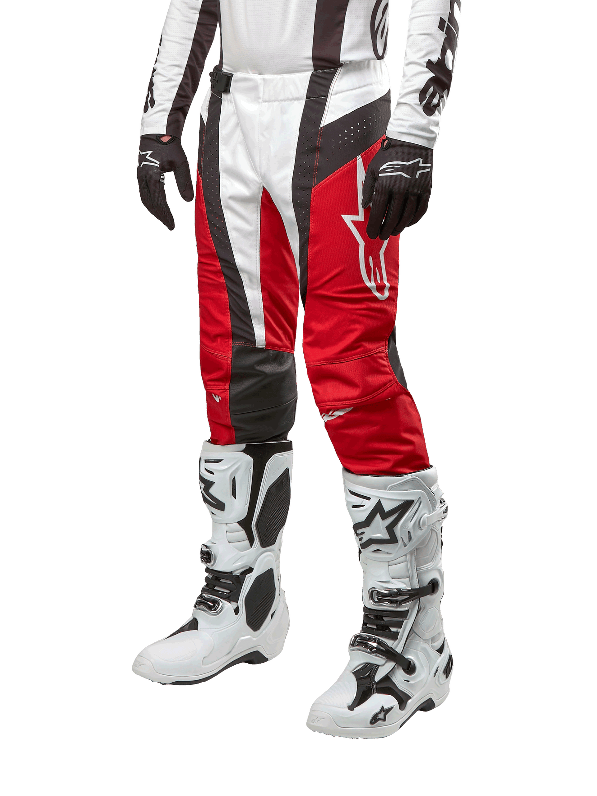 Alpinestars 2024 Techstar Ocuri Hose, Motocross-Rennsport-Hose, Mars-Rot, Weiß und Schwarz, getragen mit dazu passendem weiß-schwarzem Trikot, schwarzen Handschuhen und weißen Rennstiefeln mit Schnallen, technische Schutzausrüstung auf weißem Hintergrund