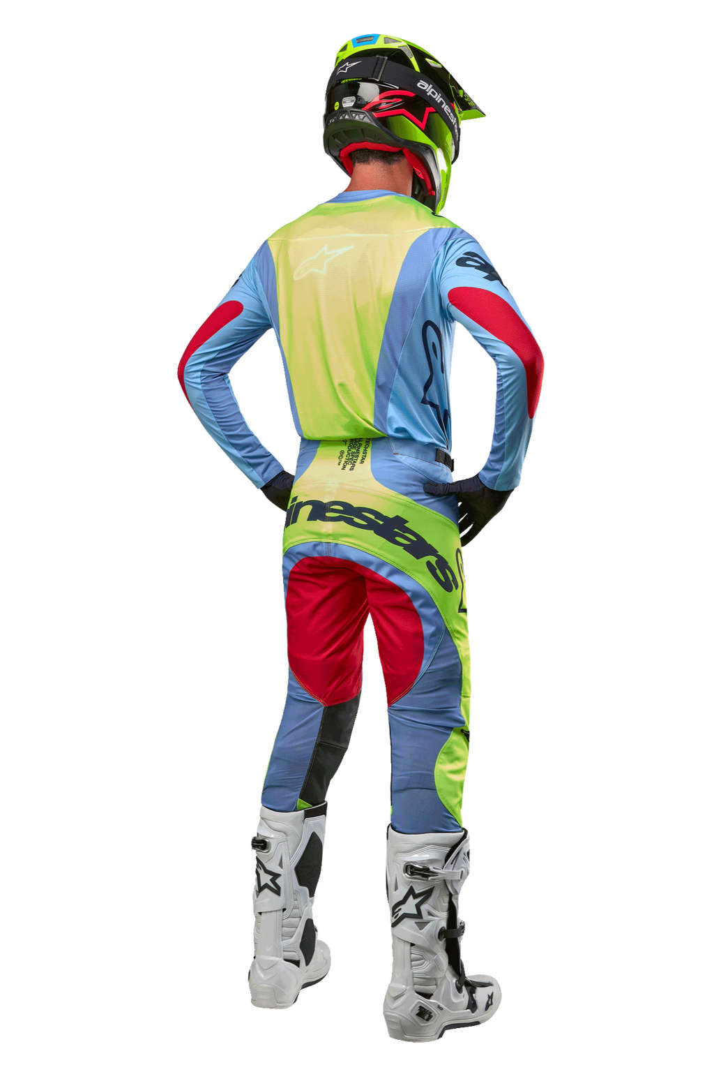 Motocross-Fahrer von hinten mit 2024 Techstar Ocuri Hose und passendem Trikot, Hellblau, Neongelb und Beerenrot, weiß-schwarze Stiefel, schwarzer Helm mit Neon-Akzenten, abgestimmte Alpinestars-Ausrüstung für Offroad-Rennen