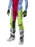Alpinestars 2024 Techstar Ocuri Hose, Motocross-Hose, Hellblau, Beerenrot und Neongelb, getragen mit passender Ausrüstung und weißen Stiefeln, mit markantem Astars-Branding und einer Performance-Rennpassform.