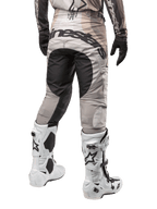Alpinestars 2024 Techstar Pneuma Hose, Motocross-Hose, Dark Sand und Iron Dust Gray, Rückansicht von der Taille abwärts, auffälliges schwarzes Alpinestars-Branding am Gesäß, kombiniert mit weiß-schwarzen Motocross-Stiefeln und schwarzen Handschuhen, strapazierfähiges Race-Fit-Design für den Offroad-Wettbewerb