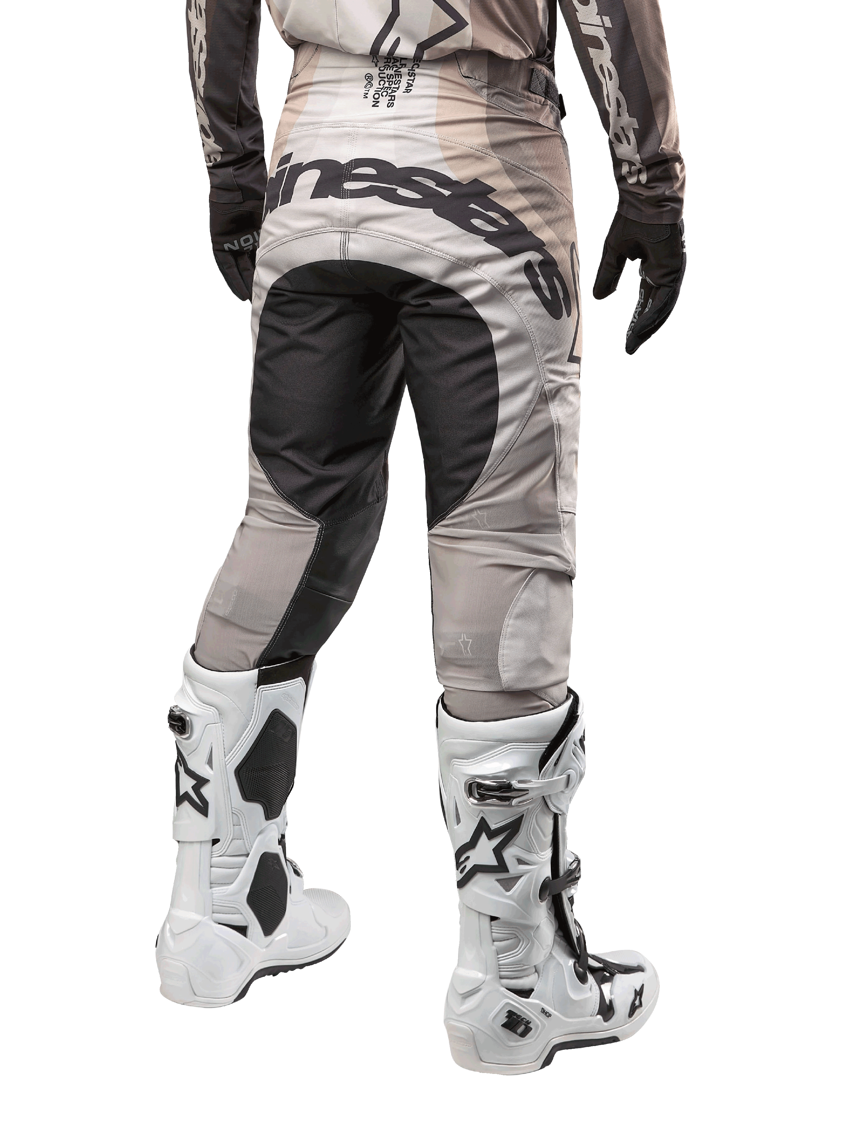 Alpinestars 2024 Techstar Pneuma Hose, Motocross-Hose, Dark Sand und Iron Dust Gray, Rückansicht von der Taille abwärts, auffälliges schwarzes Alpinestars-Branding am Gesäß, kombiniert mit weiß-schwarzen Motocross-Stiefeln und schwarzen Handschuhen, strapazierfähiges Race-Fit-Design für den Offroad-Wettbewerb