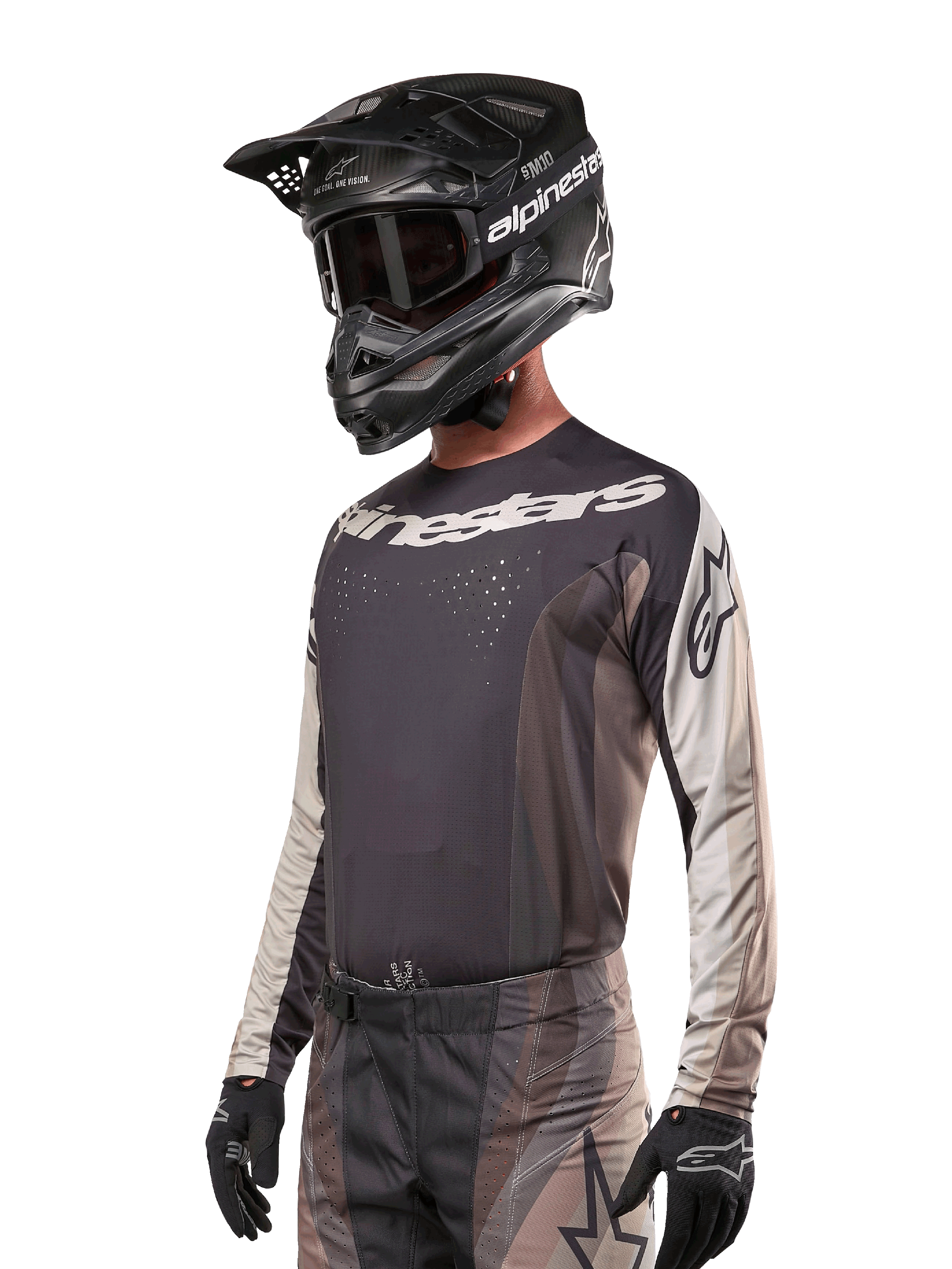Alpinestars 2024 Techstar Pneuma Jersey, Motocross-Rennsport-Trikot, Dark Sand und Iron Dust Gray, langärmeliges Performance-Oberteil mit lasergeschnittenen Perforationen und weißem Branding, getragen mit passender Hose und schwarzem Helm, athletische Passform für Offroad-Fahrten.