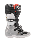 Alpinestars Youth Tech 7S Stiefel, Motocross-Stiefel, Schwarz, Silber, Weiß und Gold, Seitenansicht mit silberner Unterschale, schwarzen und weißen Paneelen am Schaft, rotem Akzent an der oberen Manschette und Drei-Schnallen-Verschlusssystem.