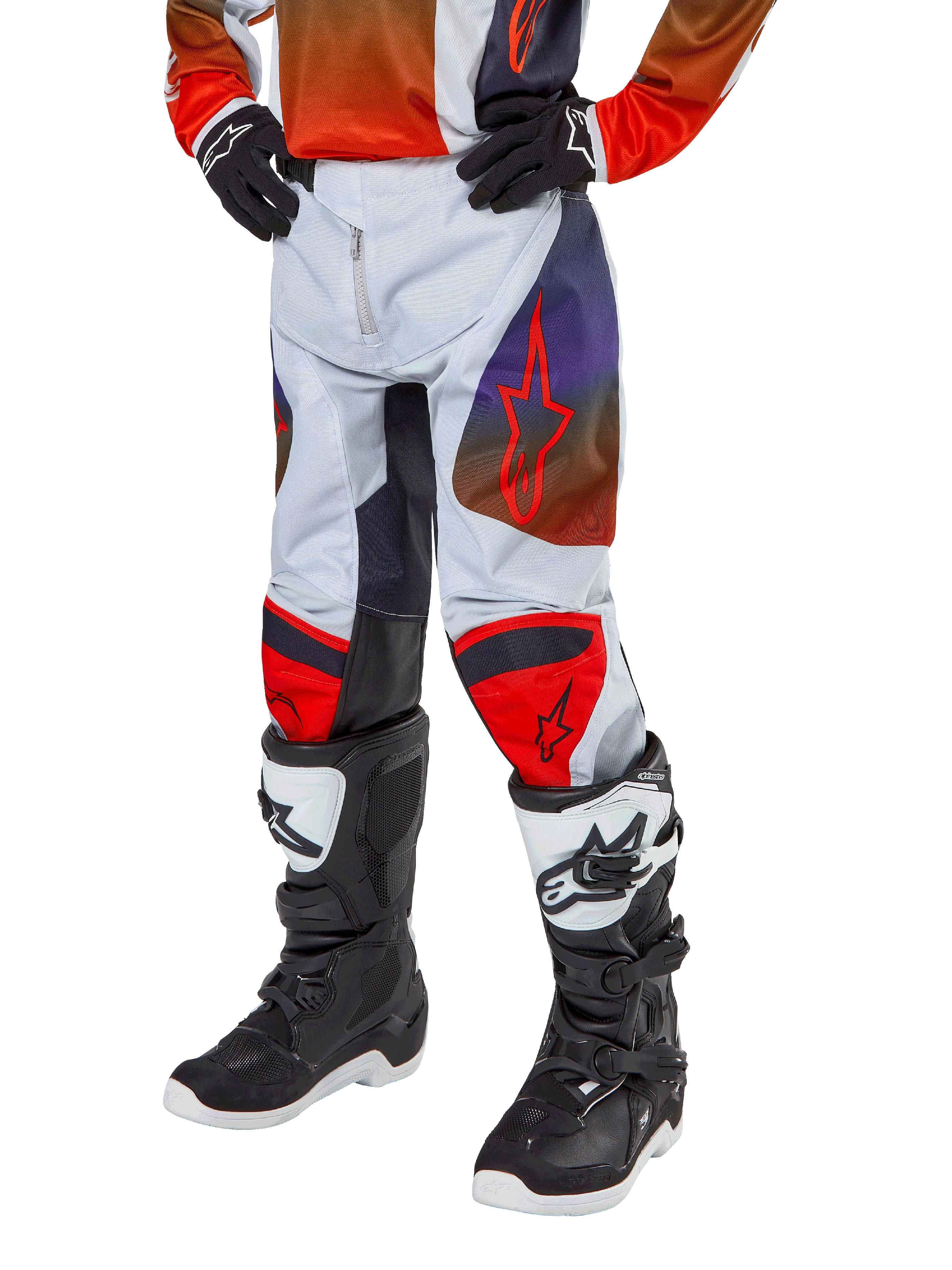 Alpinestars 2024 Youth Racer Hoen Hose, Motocross-Hose, Hellgrau mit Akzenten in Hot Orange und Schwarz, rote Stern-Logos auf den Oberschenkeln und rote Knie-Panels, getragen mit schwarz-weißen Stiefeln, strapazierfähiges Design für Offroad-Rennsport