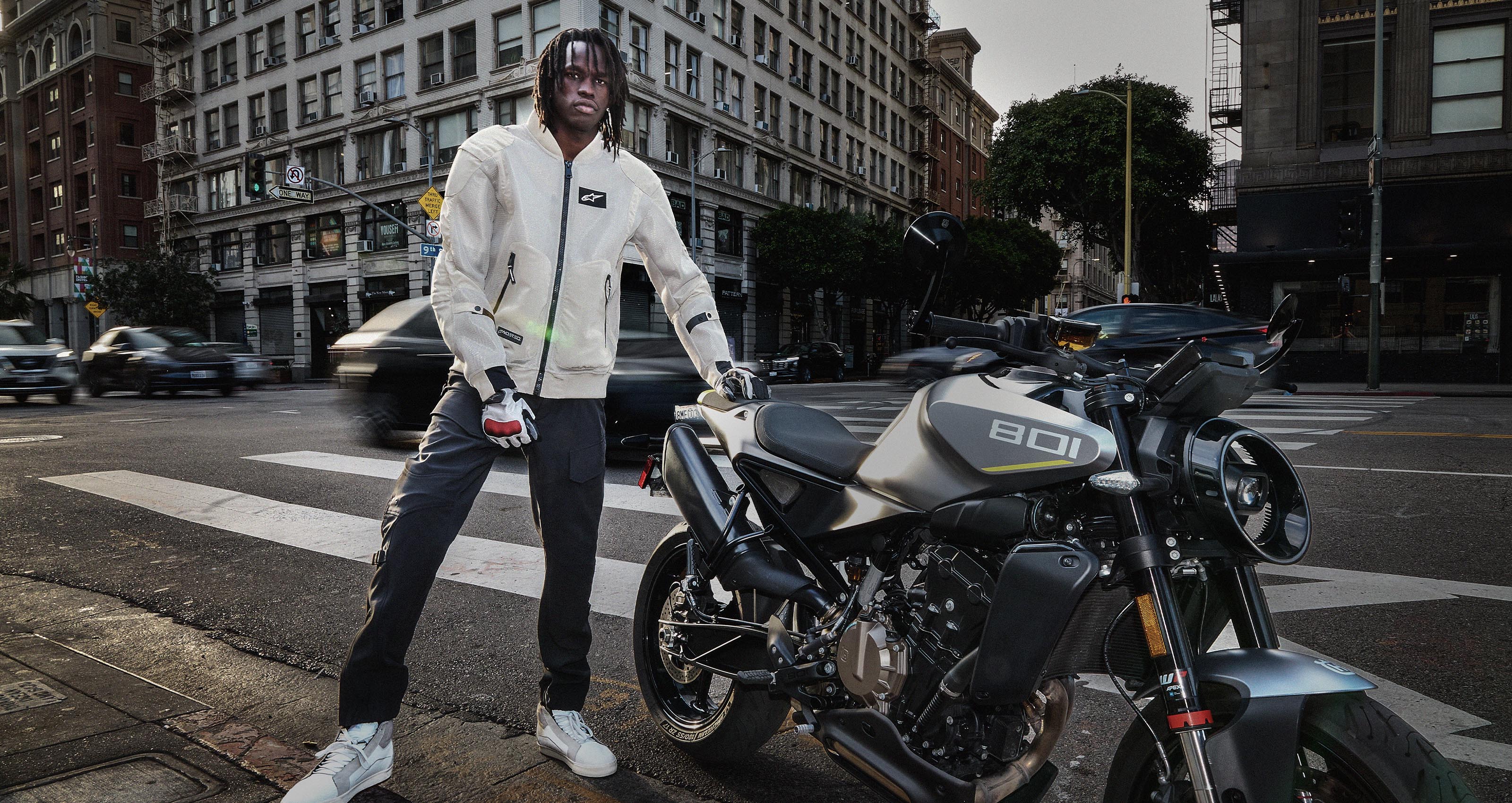Alpinestars Juggernaut V2 Riding Pants, black textile motorcycle pants for urban commuting, worn by a rider in a city setting.