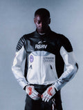RSRV Threadline Lederjacke, Schwarz und Weiß, Premium-Motorradjacke mit RSRV-Logo, gepolsterte Schultern, Reißverschlüsse, Patches "ALPINESTARS RSRV" und "ONE GOAL, ONE VISION", Person trägt weiße Handschuhe mit roten Akzenten