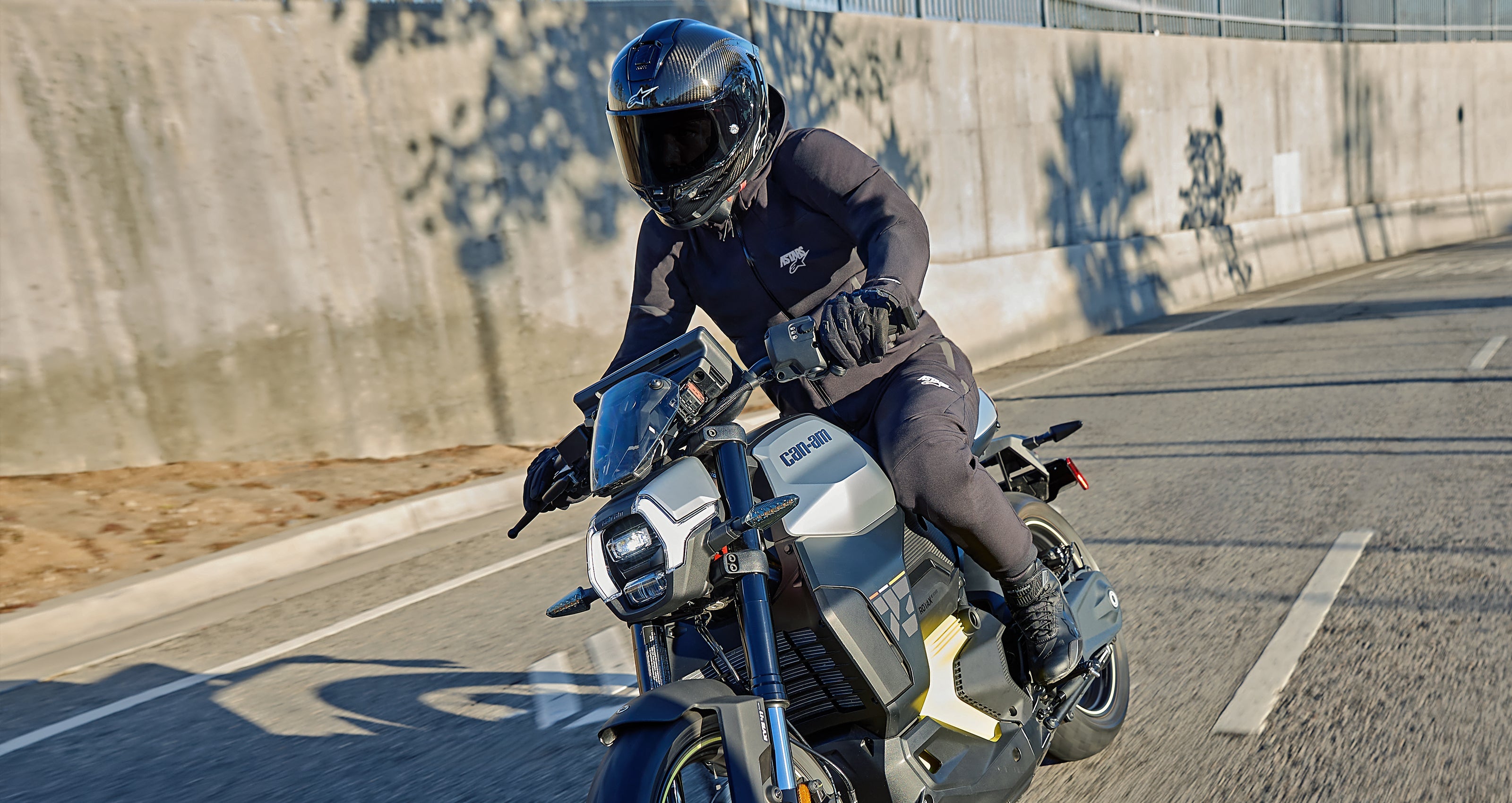 Alpinestars Aeroshell Pants and Waterproof Jacket, black textile road riding gear worn by a motorcyclist on the street.
