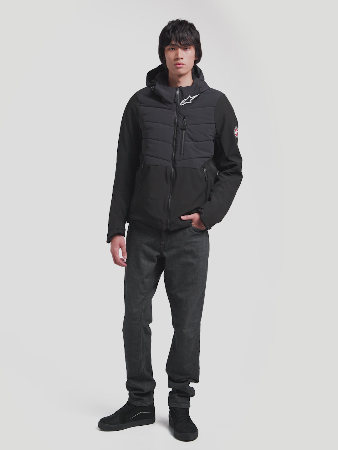 Alpinestars Therma-Tech Waterproof Jacket, men's urban contemporary motorcycle textile jacket in black, featuring sonic-welded down construction and integrated hood worn by a model.
